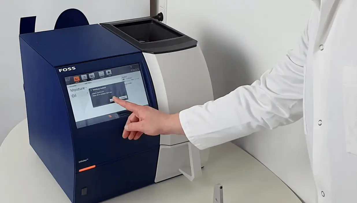 FOSS Infratec viljan proteiinianalysaattorin kosketusnäyttöliittymä, joka näyttää kosteus- ja öljyanalyysin